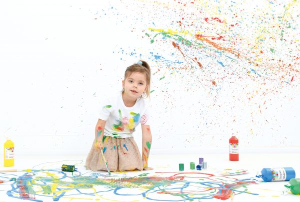 Dziewczynka malująca przy pomocy farb temperowych