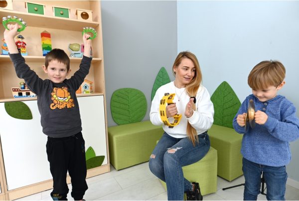 nauczycielka z dziećmi gra na instrumentach