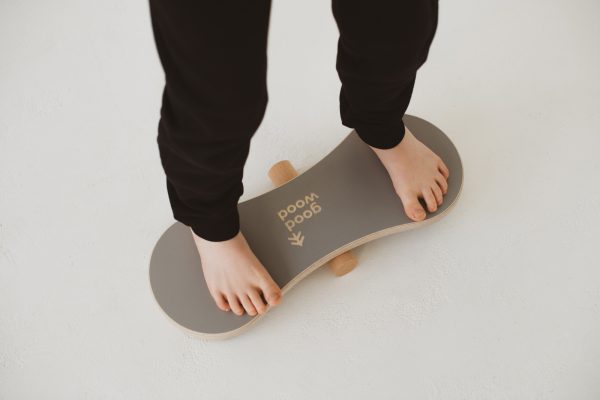 stopy chłopca na drewnianej równoważni good wood