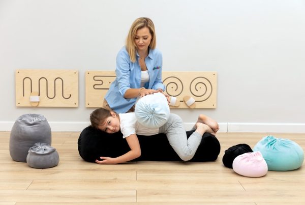 terapeuta pracuje z dzieckiem przy pomocy bukinów